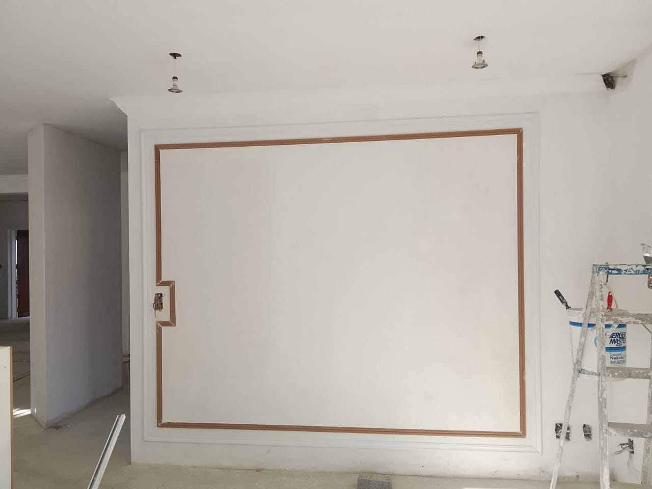 interior wall painted white with a white board that has a wooden trim